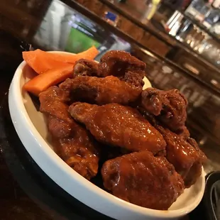 a bowl of chicken wings and carrots