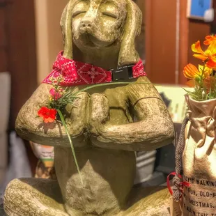 a statue of a dog holding a flower