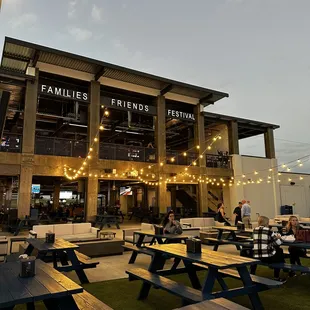 people sitting at picnic tables outside of a building