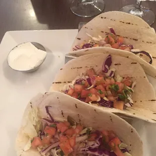 Fish tacos from the appetizer menu, with sour cream on the side