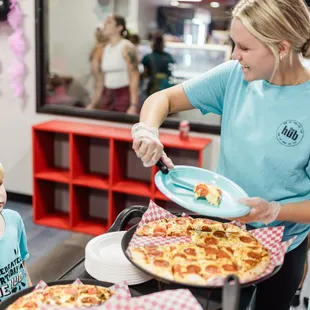 Party hosts serve pizza to your party