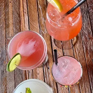 a variety of cocktails on a wooden table
