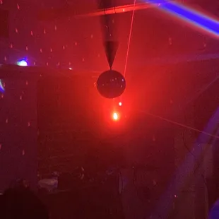 lasers, disco balls illuminate the dance floor.