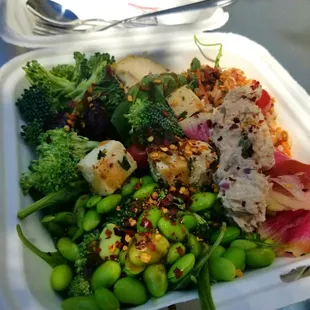 a takeout container with a salad in it