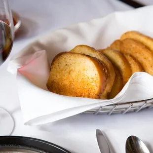 a basket of bread and a glass of wine