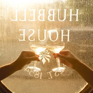 two hands holding wine glasses