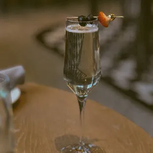 a glass of wine with a garnish on it