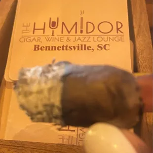 a hand holding a cigar