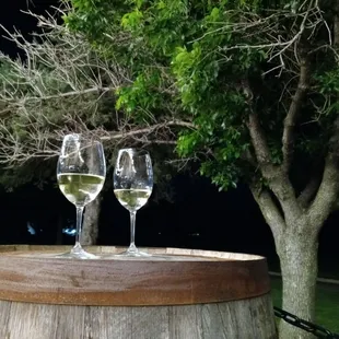 two glasses of wine on a barrel