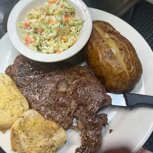 a plate of steak, potatoes, and coleslaw