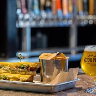 a tray of food and a glass of beer