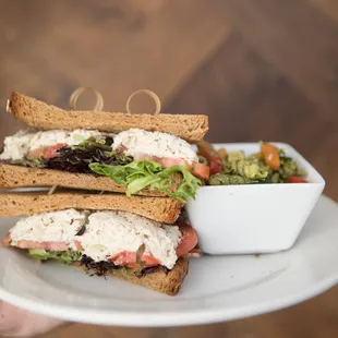 a person holding a plate with a sandwich