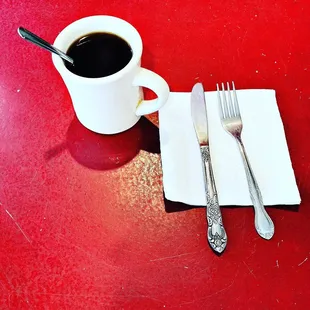 a cup of coffee and silverware