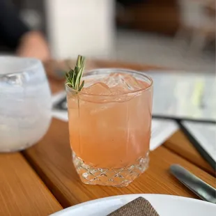 a drink with a sprig of rosemary