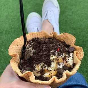 Salted caramel Oreo ice cream in a waffle bowl with crushed Oreos and caramel