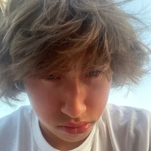 a young boy with his hair blowing in the wind