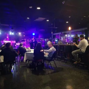 ows people sitting at tables in a dimly lit room