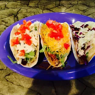 three tacos on a blue plate