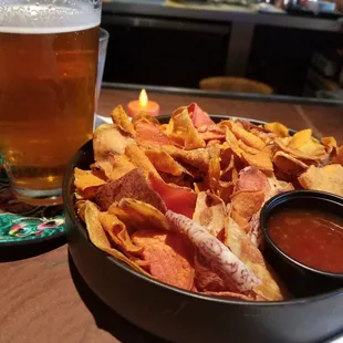 a bowl of chips and a glass of beer