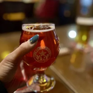 a person holding a glass of beer