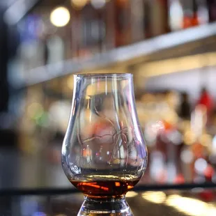 a glass of whiskey on a bar