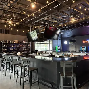 a bar with stools and a television