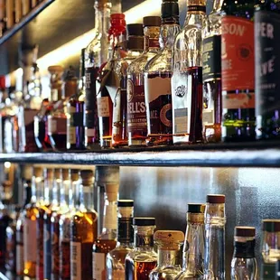 a shelf full of liquor bottles