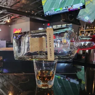 a glass of whiskey on a bar