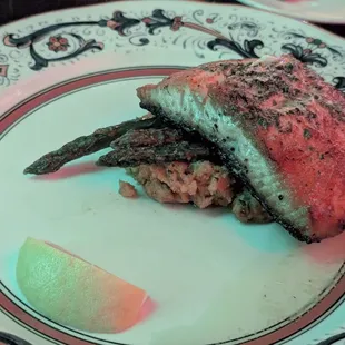 Dramatically overcooked salmon with polenta, slathered in pesto, with 3 asparagus spears, for $38, December 2024.
