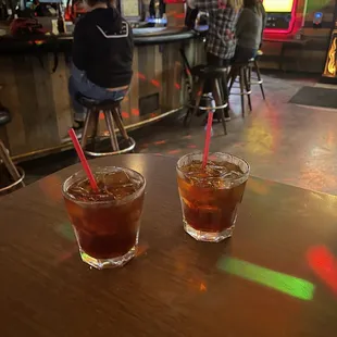 two glasses of iced tea on a bar