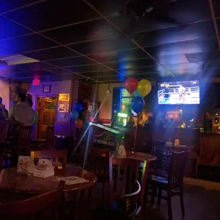 people at a bar with balloons in the air