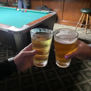 ows two glasses of beer and a pool table