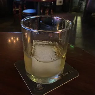 a glass of whiskey on a coaster