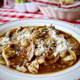 a bowl of pasta with mushrooms and parmesan cheese