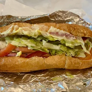 Ham, Salami, Capicola, with lettuce, tomato and dressing on a nice roll.