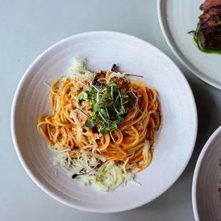 a plate of spaghetti with meat and vegetables