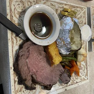 Prime Rib, corn bread, carrots, green beans, baked potato and roll.
