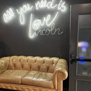 a couch and a neon sign