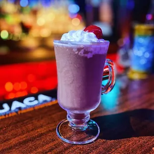 a drink with whipped cream and a cherry