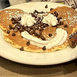 Chocolate chip pancake and sausage links, with fruit cup and chocolate Milk.