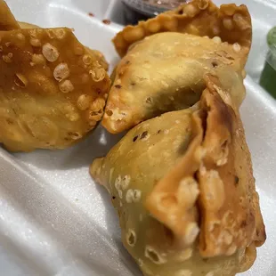 three fried pastries on a styrofoam tray