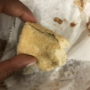 a hand holding a piece of bread