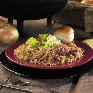 a plate of jambalaya with bread and onions