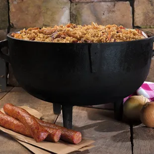 a pot of jambalaya with sausages and onions