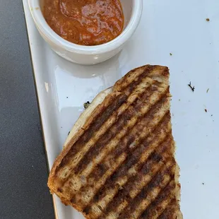 Chicken sandwich with sauce on the side.