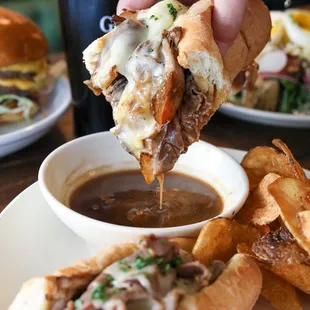 a sandwich being dipped with cheese