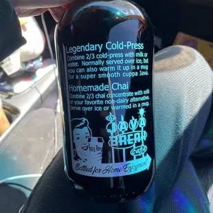 a hand holding a bottle of liquid