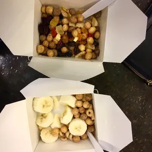 Cereal :) mix of cereals, with dried fruit topping on the top one, and banana on the bottom one.  Vanilla milk in each.