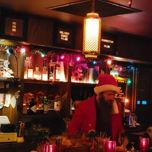 a man in a santa hat at a bar