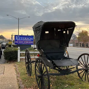 a horse drawn carriage parked on the side of the road